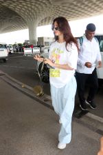 Disha Patani with sunglasses on wearing Sailor Moon Tee and Urban Renewal Vintage Overdyed French wind pant holding canon eos camera bag with New Balance Vinted Shoes